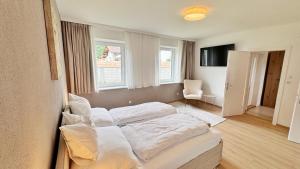 a bedroom with two beds and a chair in it at Das Markt 28 - Urlaub wie zu Hause in Kirchberg am Wechsel