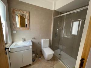 a bathroom with a toilet and a shower and a sink at Almada Negreiros in Vila Nova de Milfontes +40 photos