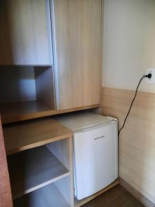 a washer and dryer sitting under a cabinet at Hotel Poty in Maracaju