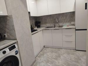 a white kitchen with a sink and a dishwasher at Njoy in Jermuk