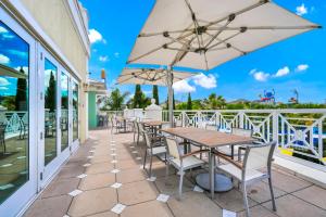 キシミーにあるCharming Home With Private Pool, Theme Rooms And Foosball Table Near Disney With Waterpark & Resort Access At Encore - 370Laのテーブルと椅子と傘のあるパティオ