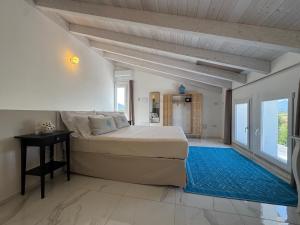 a bedroom with a large bed and a blue rug at Tenuta Feraxi - Private Paradise in Costa Rei