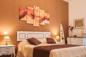 a bedroom with a bed and two paintings on the wall at Casa Ferrari Testaccio e Trastevere Wi-Fi free in Rome