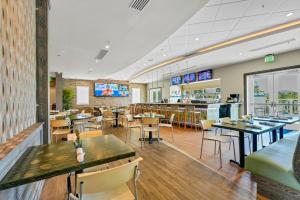 キシミーにあるCharming Home With Private Pool, Theme Rooms And Foosball Table Near Disney With Waterpark & Resort Access At Encore - 370Laのテーブルと椅子とバーのあるレストラン