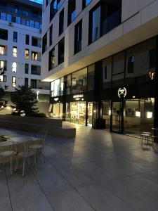 a building with chairs and tables in front of it at Herăstrău WIN Résidence No 4 in Bucharest