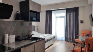 a hotel room with a bed and a kitchen with a sink at ALVINA Complex Tsaghkadzor in Tsaghkadzor