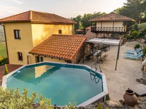 an empty swimming pool in front of a house at Las vistas in Cornellana