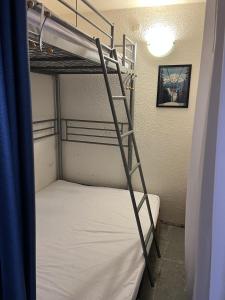 a bunk bed with a ladder in a room at Appartement Lunik Orion, 6 personnes, vue piste, Le Corbier, Les Sybelles in Villarembert