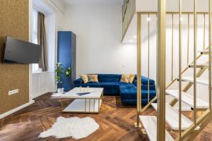 a living room with a blue couch and a table at Csarnok Apartment in Budapest