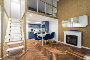a living room with a dining room table and a fireplace at Csarnok Apartment in Budapest