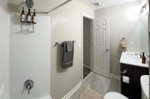 a white bathroom with a sink and a toilet at New! 10 Guest! King Bed! Patio! Grill! Near ATL & Downtown Norcross in Norcross