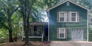 a small green house with a porch and a tree at New! 10 Guest! King Bed! Patio! Grill! Near ATL & Downtown Norcross in Norcross