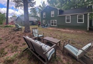 a yard with two chairs and a table and a house at New! 10 Guest! King Bed! Patio! Grill! Near ATL & Downtown Norcross in Norcross +32 photos