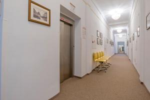 a hallway with a row of yellow chairs in a building at Hotel Metropol in Františkovy Lázně