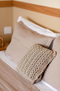 a white bed with a crochet pillow on it at Fortmar Hotel in Fortaleza