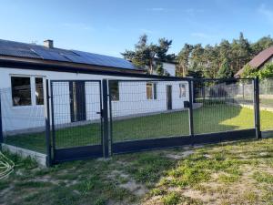 a chicken coop with a fence in a yard at Agroturystyka nad stawem 
