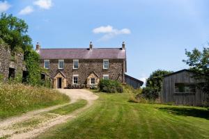 an old stone house with a dirt road at Charming Rural Escape with Hot Tub Play Room BBQ in Llawhaden