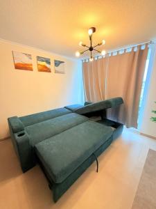a living room with a green couch and a window at Departamento con piscina a pasos de la playa en La Serena in La Serena