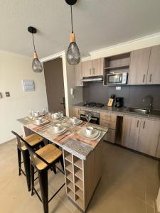 a kitchen with a large island with a table and chairs at Departamento con piscina a pasos de la playa en La Serena in La Serena