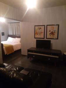 Un dormitorio con una cama y un escritorio con televisión. en The Concept, en Centurion