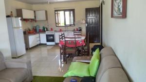 a living room with a couch and a table and a kitchen at CASA COM 3 QUARTOS, SENDO 1 QUARTO Suite in Pinhal