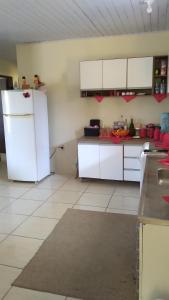 a kitchen with white cabinets and a white refrigerator at CASA COM 3 QUARTOS, SENDO 1 QUARTO Suite in Pinhal