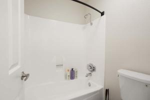 een witte badkamer met een toilet en een licht erboven bij Marina Edge Bright 1BR 1BA Condo by the Beach in Los Angeles +9 foto's