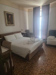 a bedroom with a bed and a chair and a window at ROOMS CA' TUNIN- ideale per il Trenino Rosso- a pochi minuti a piedi dalla stazione in Tirano +9 photos