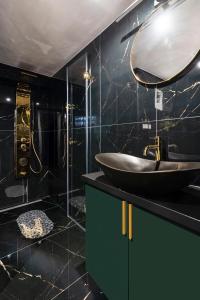 a black bathroom with a sink and a mirror at Csarnok Apartment in Budapest +39 photos