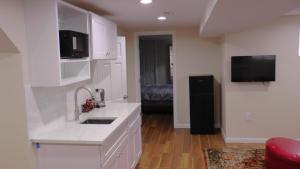 cocina con armarios blancos, fregadero y TV en Lincoln Howard House, en Washington 14 fotos más