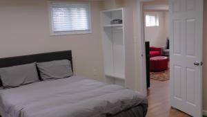 Un dormitorio con una cama y una silla roja. en Lincoln Howard House, en Washington