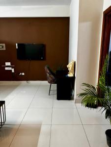 a living room with a flat screen tv and a chair at Luxurious 2 Bed Apartment in Islamabad