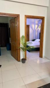 a bedroom with a bed and a potted plant at Luxurious 2 Bed Apartment in Islamabad