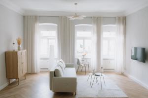 a white living room with a couch and a table at Arkanum Studio in Altenburg