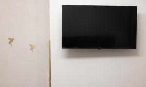 a flat screen tv hanging on a white wall at My Home in Barletta