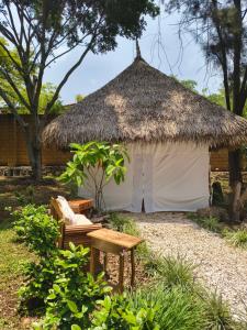 a white hut with a bench and a table at Paraje Real Malinalco in San Martín