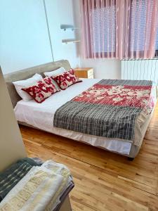 a bedroom with a bed with red pillows on it at City Square Apartment 1st floor in Strumica
