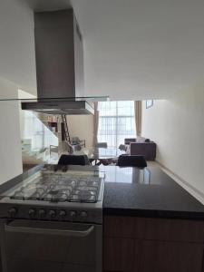 cocina con fogones y sala de estar. en Casa Ambar, en Morelia