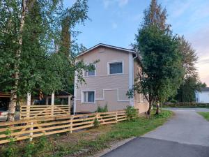 a house with a wooden fence in front of it at countryside next to center in Kemi