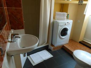 Un baño con lavadora y lavabo. en Daukanto Apartments, en Vilna