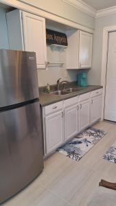 a kitchen with a stainless steel refrigerator and white cabinets at Near Beach Walk and Bike everywhere FENCED BACKYARD in Naples +13 photos