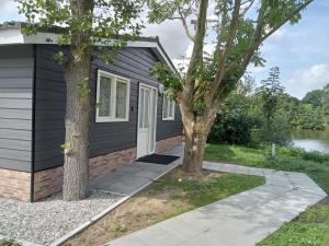 a home with a black house and two trees at Domstad Resort Utrecht Vakantiewoningen in Utrecht