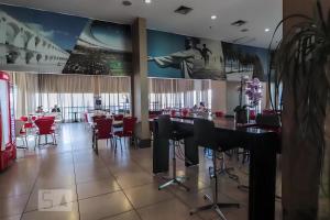 une salle à manger avec des chaises et des tables rouges ainsi qu'un restaurant dans l'établissement Rio Plaza - Suítes no Rio de Janeiro por Carpediem, à Rio de Janeiro