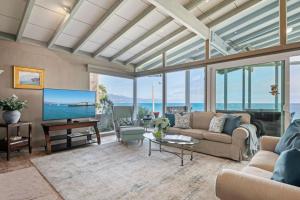 a living room with a couch and a tv at Surfers Paradise in Santa Barbara +30 photos