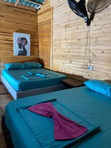 two beds in a room with wooden walls at Brisas del Mar vista al Mar in Playa Blanca