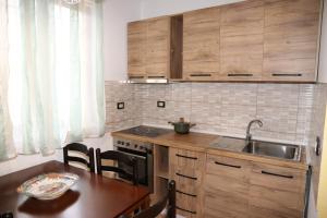 a kitchen with wooden cabinets and a table and a sink at Albania Studio Apartament in Tirana