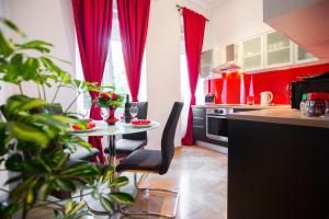 a kitchen with red curtains and a table with chairs at VisitZagreb Ruby in Zagreb