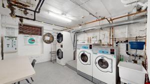 a laundry room with two washing machines and a table at Sunlit 2BR Central Park North elevator & laundry in New York