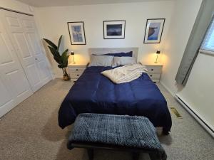 a bedroom with a large blue bed and a bench at The Hilltop in Whitehorse