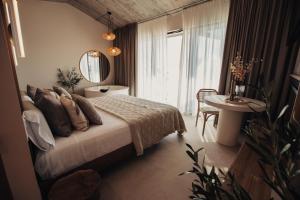 サンティリャーナ・デル・マルにあるNiditas PREMIUM SUITES & SPAのベッドとテーブルと鏡のある寝室